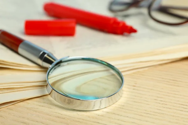 木製のテーブルの上の新聞 拡大鏡 マーカーと眼鏡のスタック 検索の概念 — ストック写真