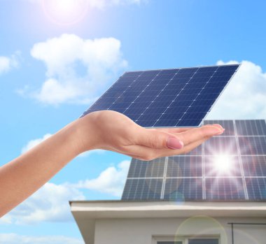 Güneş panelini dışarıda gösteren bir kadın, yakın plan. Alternatif enerji kaynağı 