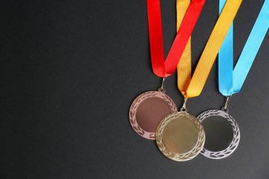 Siyah arka planda altın, gümüş ve bronz madalyalar, düz yatış. Tasarım için boşluk