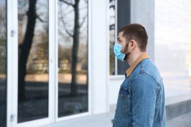 Açık havada tek kullanımlık maske takan bir adam. Tehlikeli bir virüs.