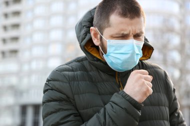 Açık havada tek kullanımlık maske takan bir adam. Tehlikeli bir virüs.