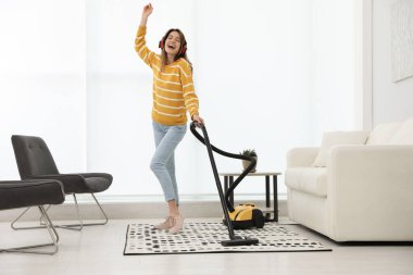 Evini süpürürken eğlenen genç kadın.