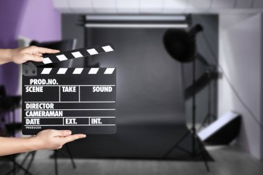 Asistan çekim yeri için el çırpma tahtası tutuyor, yakın çekim. Sinema yapımı 