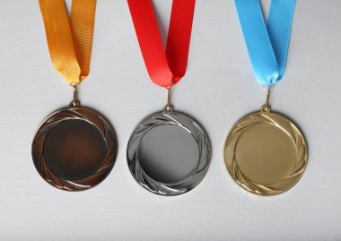 Beyaz arka planda altın, gümüş ve bronz madalyalar, düz yatış. Tasarım için boşluk