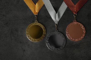 Gri taş arka planda altın, gümüş ve bronz madalyalar, düz yatış. Tasarım için boşluk