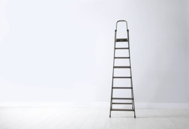 Beyaz duvarın yanındaki modern metal merdiven. Metin için boşluk