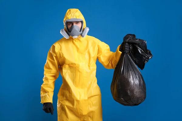 Uomo Tuta Protettiva Chimica Con Sacchetto Della Spazzatura Sfondo Blu — Foto Stock