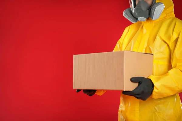 Homem Terno Proteção Química Segurando Caixa Papelão Fundo Vermelho Vista — Fotografia de Stock