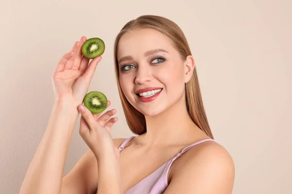 Jonge Vrouw Met Gesneden Kiwi Beige Achtergrond Vitaminerijk Voedsel — Stockfoto
