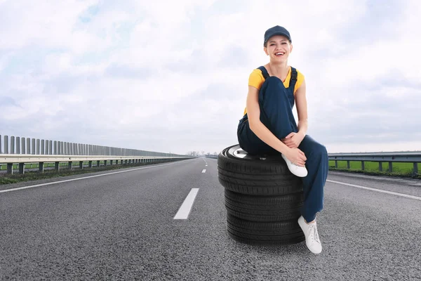 Mechanik Mundurze Oponami Samochodowymi Asfaltowej Autostradzie Zewnątrz Miejsce Tekst — Zdjęcie stockowe