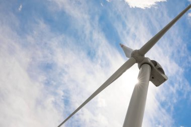Bulutlu gökyüzüne karşı modern rüzgar türbini, düşük açı. Alternatif enerji kaynağı