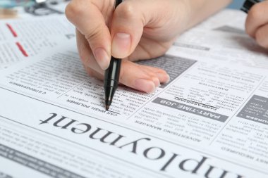 Gazetede ilan veren kadın, yakın çekim. İş arama konsepti