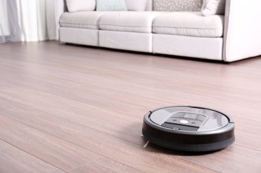 Modern robot elektrikli süpürgeyle yerleri süpürüyor. Metin için boşluk