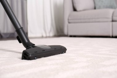 Modern elektrikli süpürgeyle yerleri süpürmek, yakın plan. Metin için boşluk