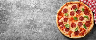 Gri masadaki sıcak ve lezzetli pizzanın üst görüntüsü, mesaj için yer. Pankart tasarımı 