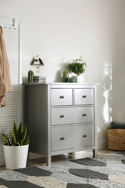 Серый комод в стильном интерьере комнаты