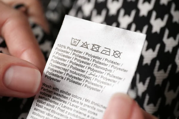 Kobieta Czytająca Etykietę Odzieży Symbolami Pielęgnacji Zawartością Materiału Koszulce Zbliżenie — Zdjęcie stockowe