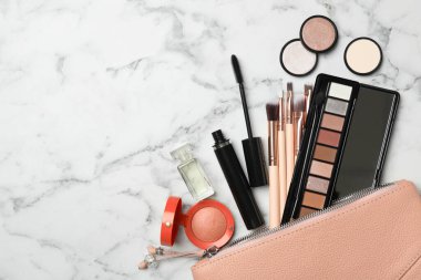 Makyaj malzemelerinin beyaz mermer arka planda olduğu kozmetik çanta. Metin için boşluk