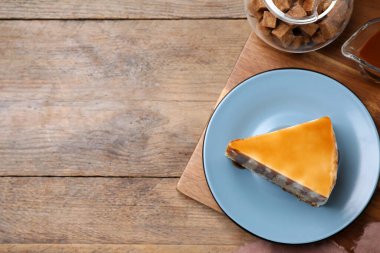 Tahta masada karamel soslu lezzetli bir pasta dilimi. Metin için boşluk