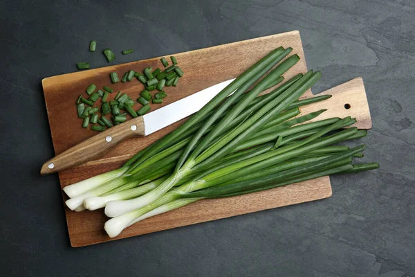 Cebolletas Verdes Frescas Tabla Cortar Cuchillo Mesa Negra Vista Superior —  Fotos de Stock