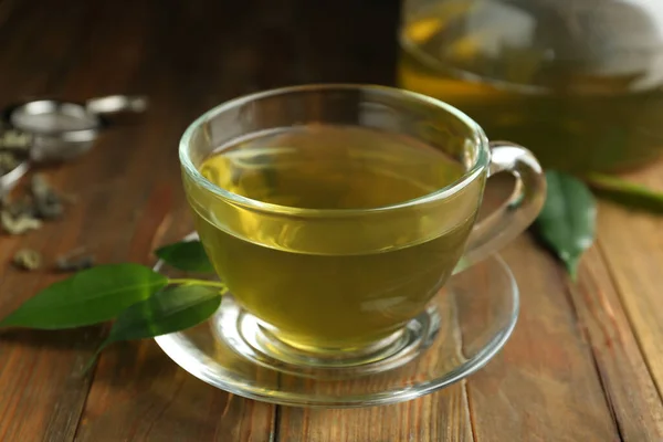 Tasse Aromatischer Grüner Tee Und Blätter Auf Holztisch — Stockfoto