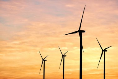 Gün batımında rüzgar türbinlerinin siluetleri. Alternatif enerji kaynağı