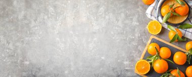 Yapraklarla dolu taze mandalinalar ve açık mermer masa üzerindeki yazı için yer, üst manzara. Pankart tasarımı 