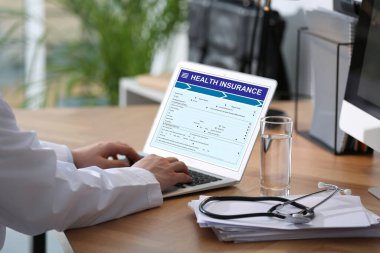 Modern dizüstü bilgisayarı olan bir doktor, yakın plan. Sağlık sigortası