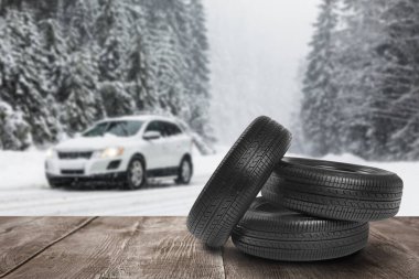 Tahta yüzeyde kar lastikleri ve arabayla kış manzarası