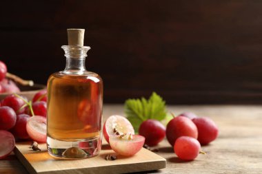 Bir şişe doğal üzüm tohumu yağı ahşap masada, yazı için yer var. Organik kozmetik