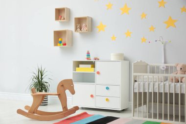 Bebek odasının içinde beşik ve oyuncaklar var.