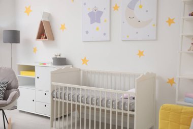Beşik ve dekorasyon elementleri olan şık bir bebek odası.