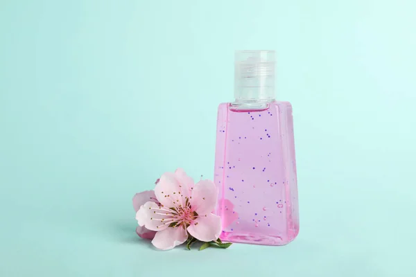 Flasche Mit Antiseptischem Gel Und Blumen Auf Hellblauem Hintergrund — Stockfoto