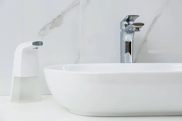 浴室水槽附近的现代自动肥皂分配器 特写镜头 — 图库照片