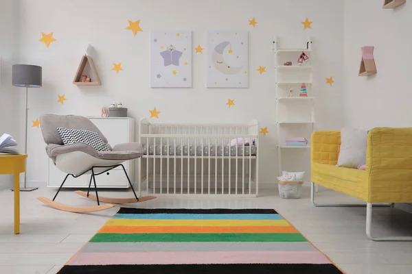 有婴儿床 摇椅和沙发的时髦婴儿房内部 — 图库照片