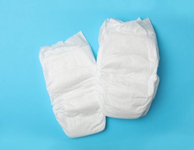 Açık mavi arka planda bebek bezleri, düz yatış