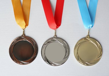 Beyaz arka planda altın, gümüş ve bronz madalyalar, düz yatış. Tasarım için boşluk