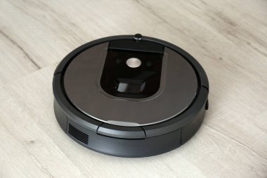 Ahşap zeminde modern robot süpürge.