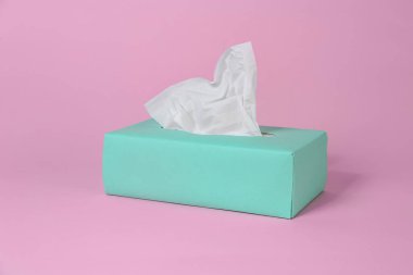 Pembe arka planda kağıt mendil kutusu
