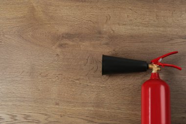 Ahşap arka planda yangın söndürücü, üst manzara. Metin için boşluk