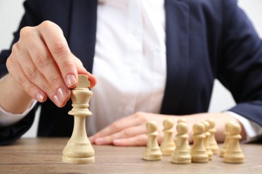 Ahşap masada satranç taşı taşıyan kadın, yakın plan. Kariyer tanıtımı konsepti