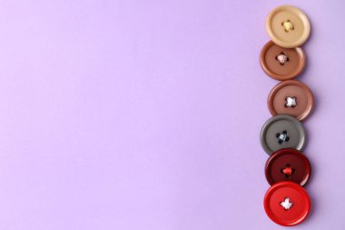 Menekşe arkaplanda bir sürü renkli dikiş düğmesi var. Metin için boşluk