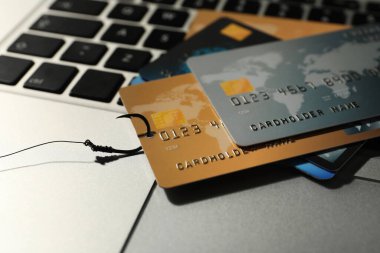 Laptopta kredi kartlarıyla balık oltası, yakın plan. Siber Suçlar