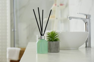 Reed oda spreyi ve ev bitkisi banyoda tezgahta.