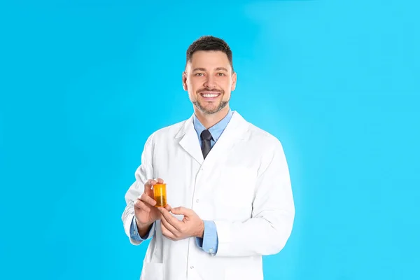 薄い青の背景に丸薬とプロの薬剤師 — ストック写真