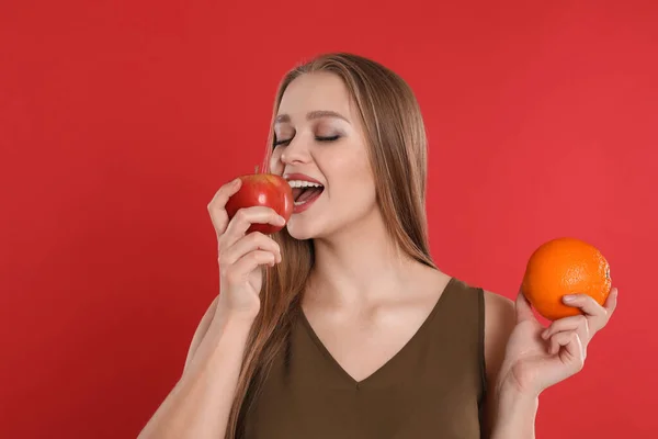 Mujer Joven Con Manzana Naranja Sobre Fondo Rojo Alimentos Ricos — Foto de Stock