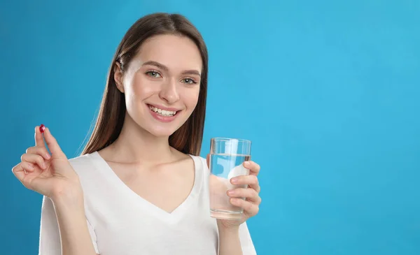 Young Woman Vitamin Pill Glass Water Blue Background — Stock Photo, Image