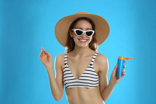 Junge Frau Mit Sonnenschutzcreme Auf Hellblauem Hintergrund — Stockfoto