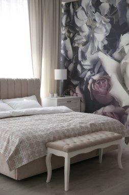 Yatak odasının iç kısımlarında duvar kağıdı olarak kullanılan güzel bir çiçek resmi.