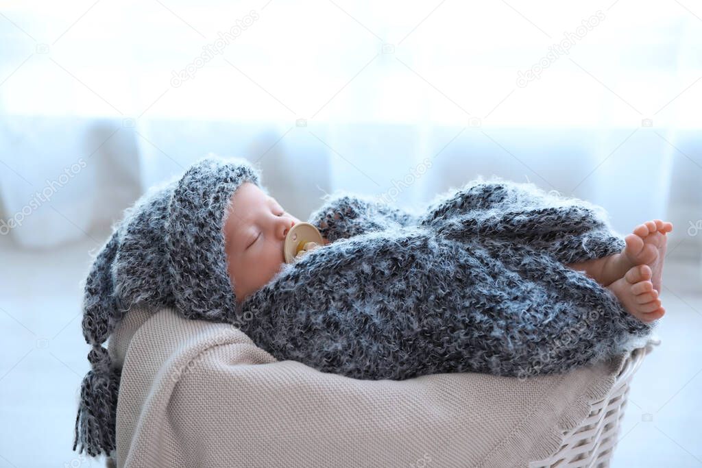 Cute newborn baby sleeping in basket at home